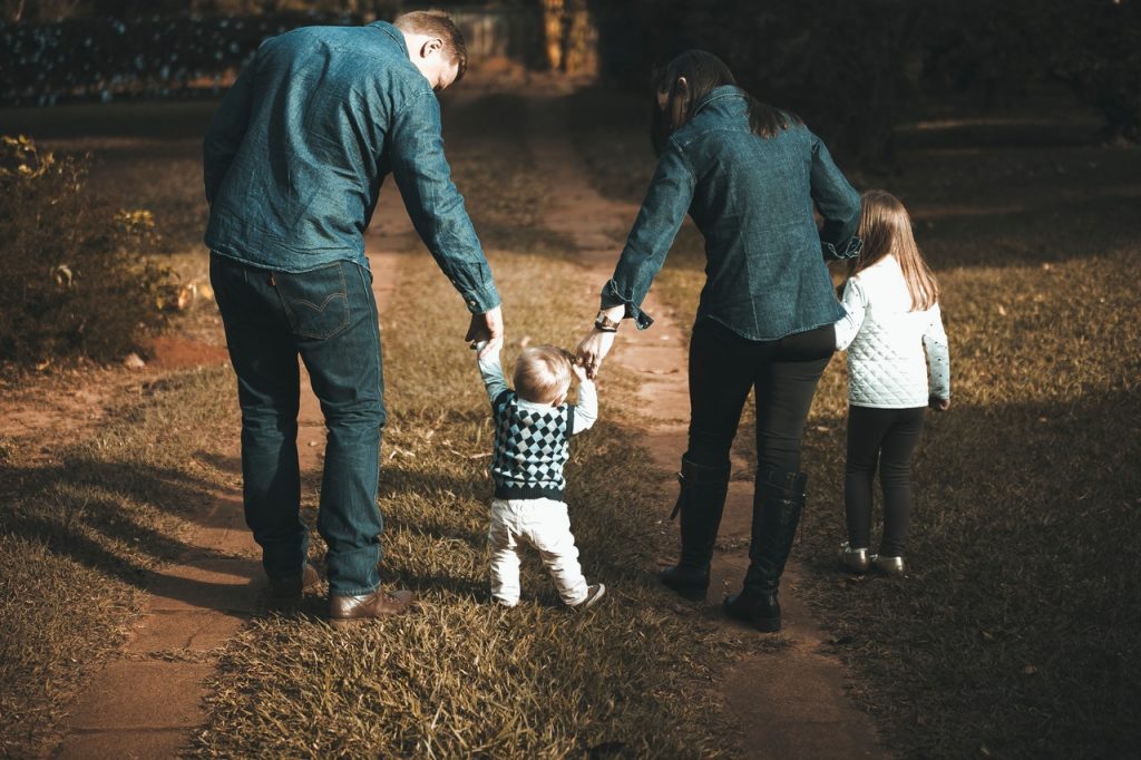 Rodzice z dziećmi idący trzymając się za ręce.