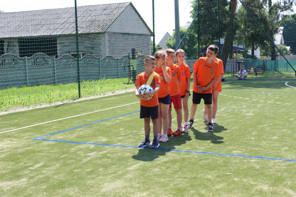dzieci uczestniczą w zawodach sportowych, biegają, rzucają piłką.