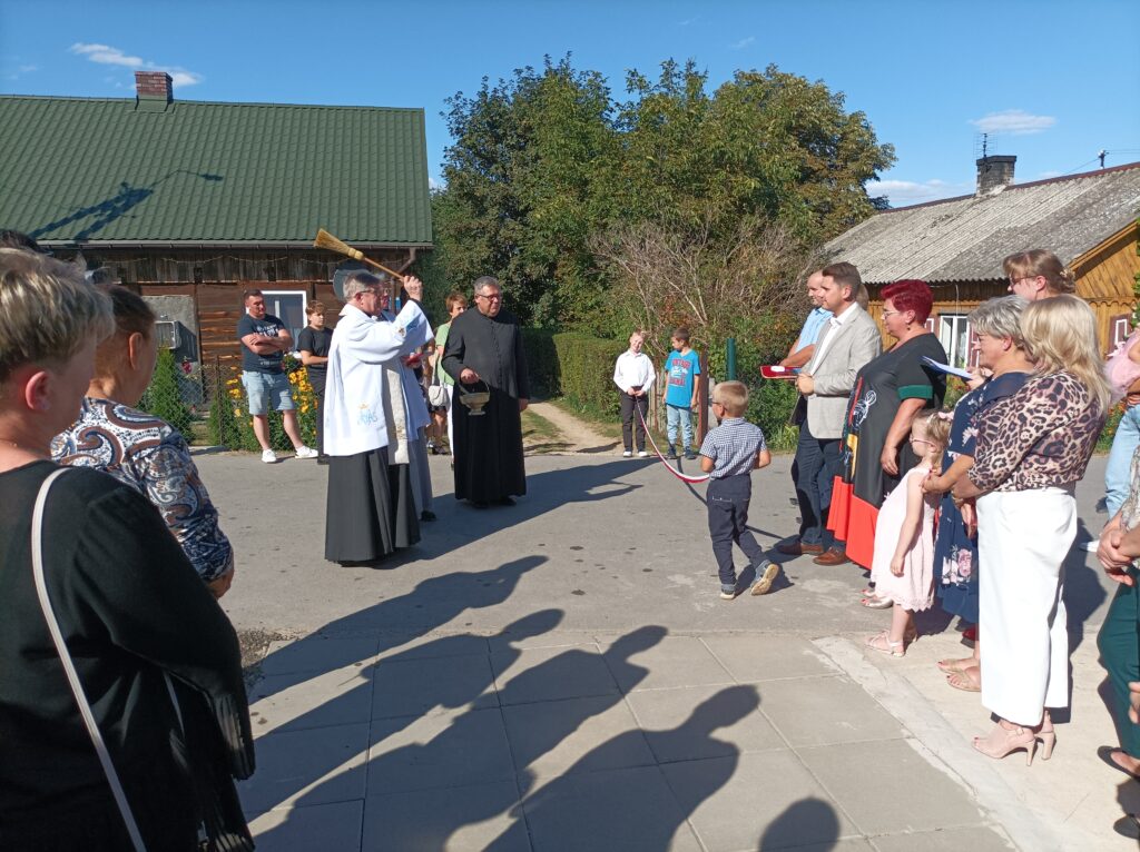 Zdjęcie przedstawiające zebranych mieszkańców oraz gości podczas Uroczystego otwarcia świetlicy wiejskiej i przebudowanej drogi gminnej w Budach Kumińskich.