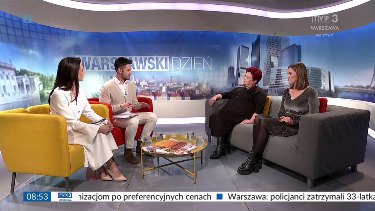 cztery osoby siedzące na dwóch kanapach po środku stolik