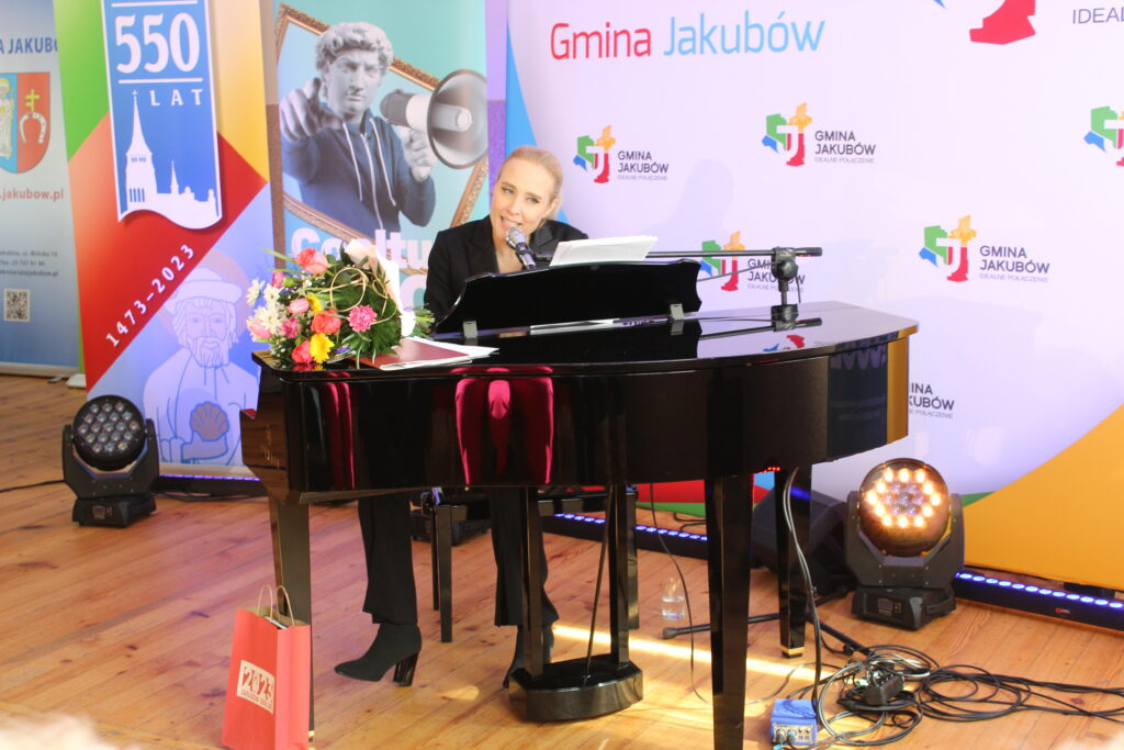 Zdjęcia przedstawiają relację z koncertu w sali OSP Jakubów. Występujący i goście na krzesłach.