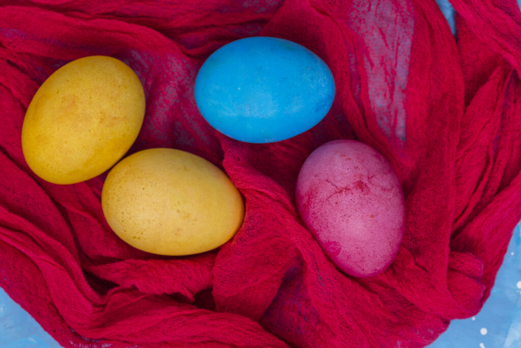 kolorowe jajka na czerwonym płótnie