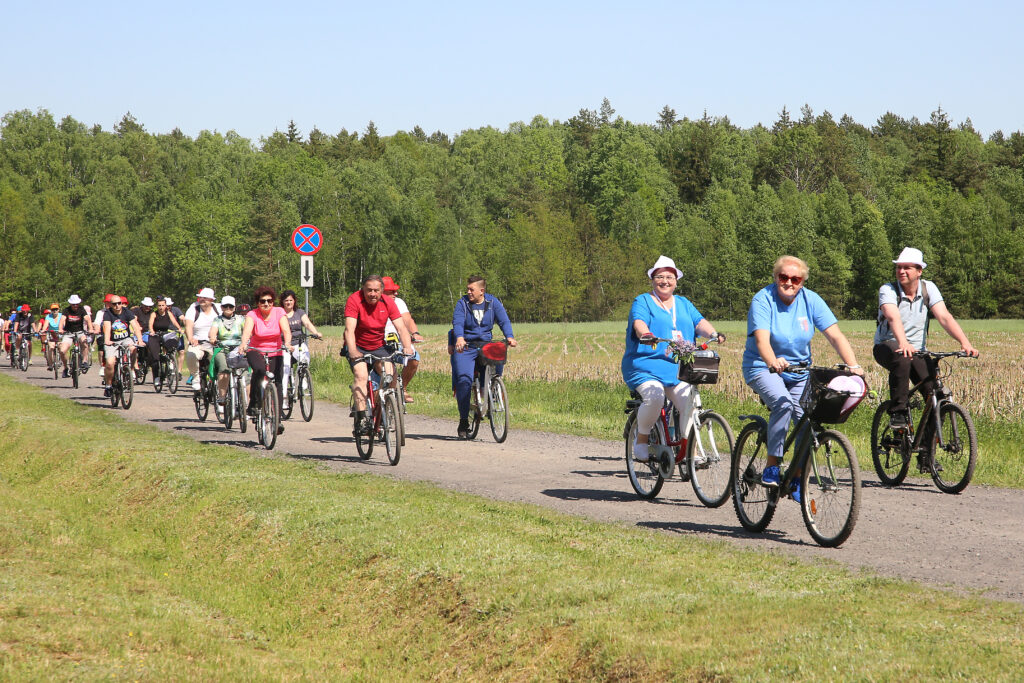 Gminny Rajd Rowerowy. Zdjęcia przedstawiają rowerzystów na trasie rajdu oraz na mecie.