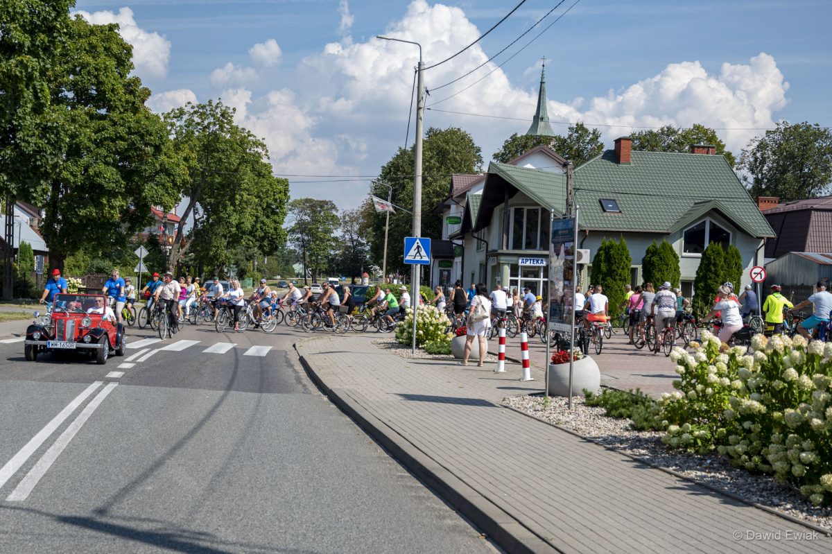 Na zdjęciach widać osoby jadące na rowerach, czerwony zabytkowy samochód z odkrytym dachem, które przemierzają trasę przez lasy, pola tereny zabudowane.