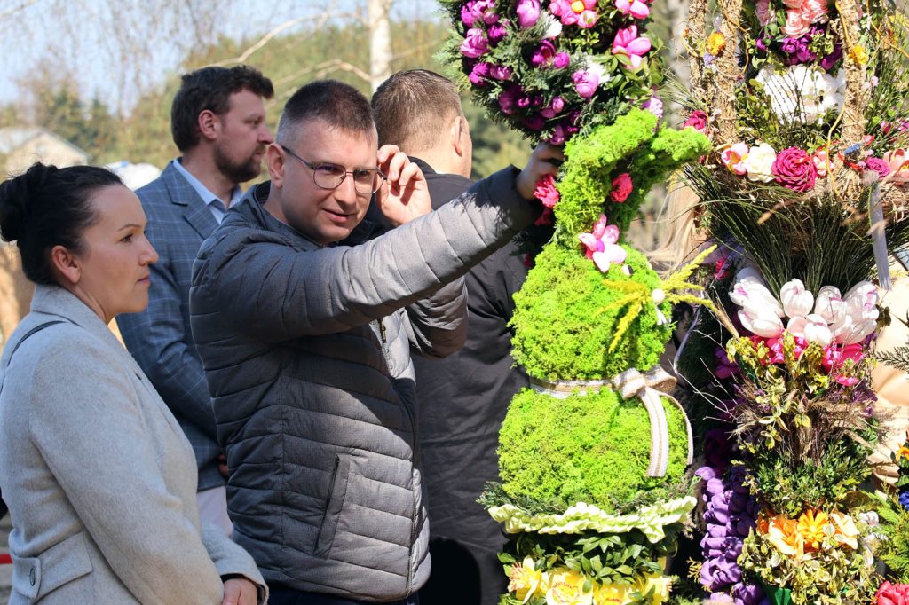 Na obrazku ludzie pojawiają się duże kwiaty kwiatowe, które składają się z podstawowych, intensywnych kolorów kwiatów i liści. Cała scena ma miejsce na świeżym powietrzu, co stanowi dodatek do uroku temu wdowisku.
